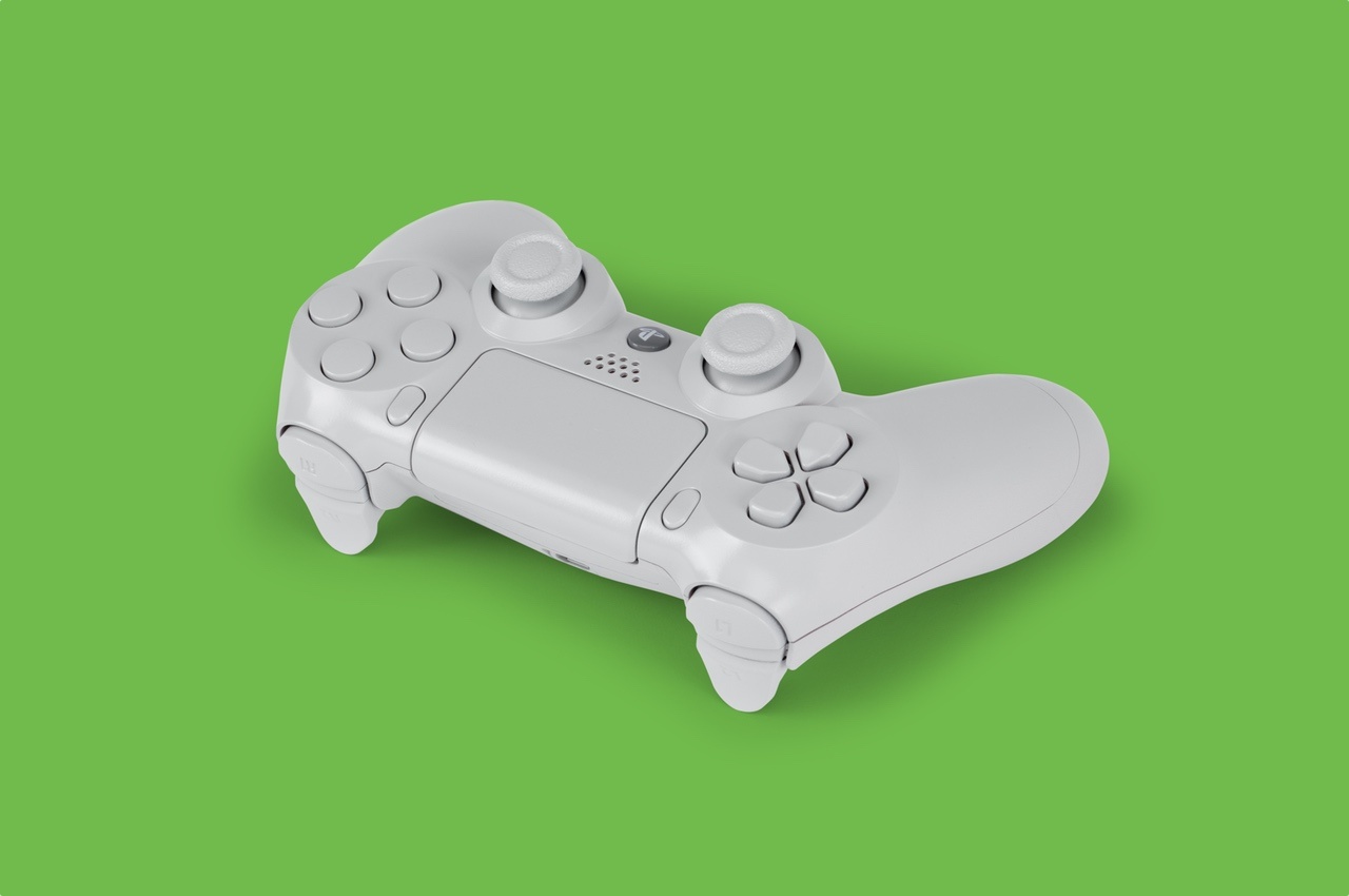 A white gamepad on a green background